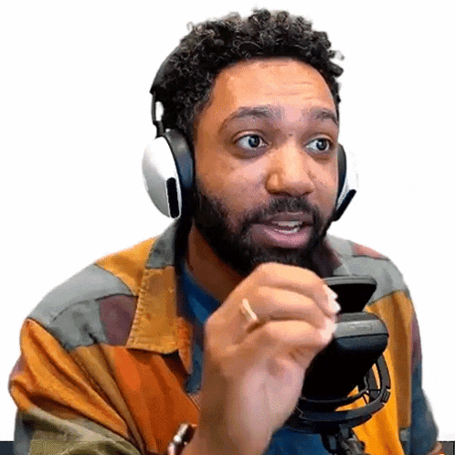 a man with a beard is wearing headphones and holding a cell phone in his hand .