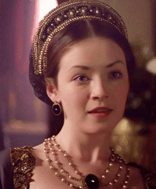 a close up of a woman wearing a necklace and headpiece