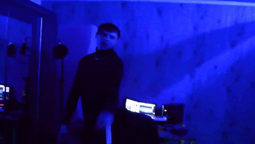 a man standing in a dark room with blue lights