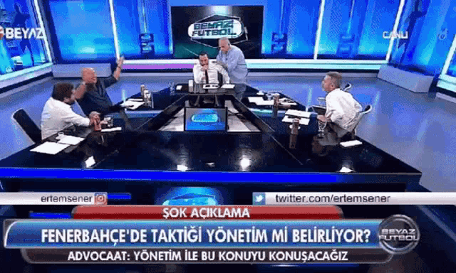 a group of men are sitting around a table in a news studio with the words fenerbahce on the top