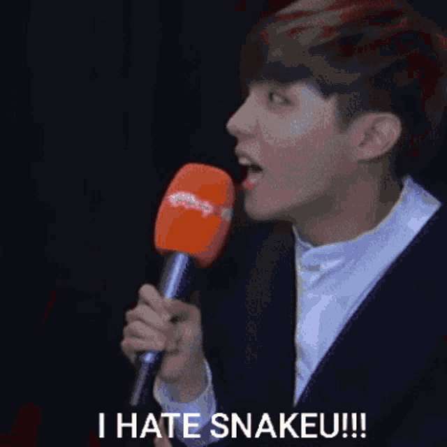 a man is holding a microphone and saying i hate snakes