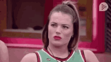a woman is wearing a green and red basketball jersey and making a funny face .