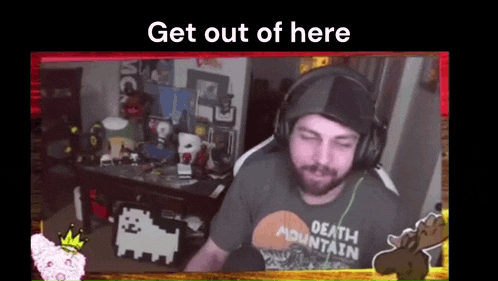 a man wearing headphones and a death mountain shirt is sitting in front of a desk