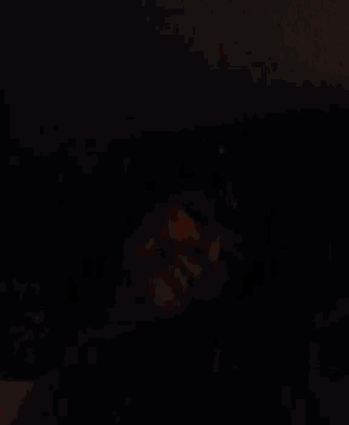 a person 's face is visible in the dark in a room .