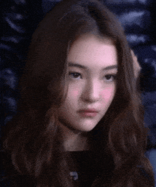 a close up of a woman 's face with a slight smirk