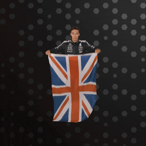 a person holding up a british flag with a black background