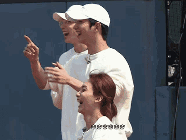 a man in a white hat is pointing up at something