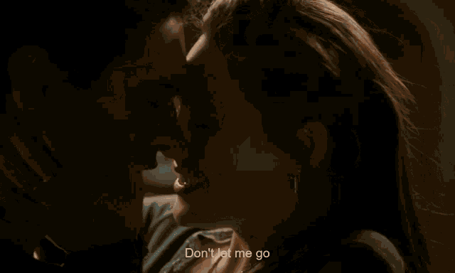 a man and a woman are kissing with the words " don 't let me go " visible