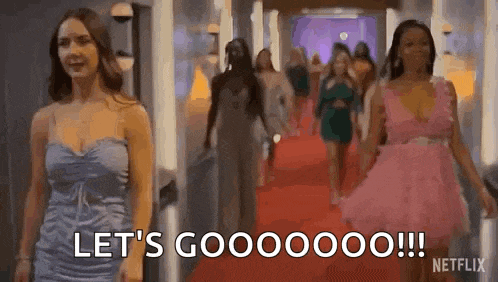 a group of women are walking down a red carpet and one of them is saying `` let 's gooooo !!! '' .