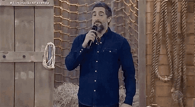 a man with a beard is holding a microphone in his hand .