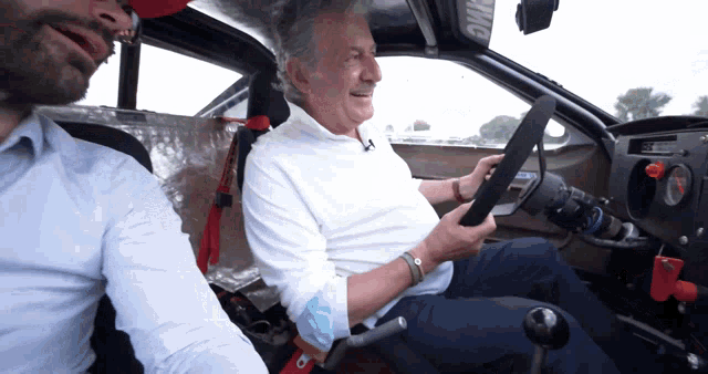 a man sitting in a car with a steering wheel that says omg on it