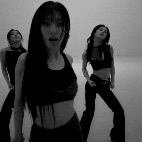 a woman in a crop top is standing next to two other women
