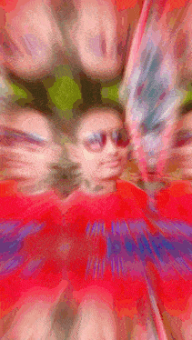 a blurry picture of a person wearing sunglasses and a red shirt that says ' i am a unicorn '