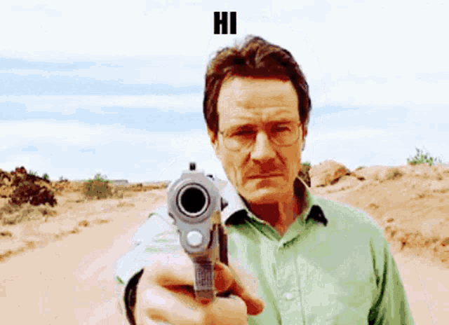 a man in a green shirt is pointing a gun at the camera with the word hi above him .