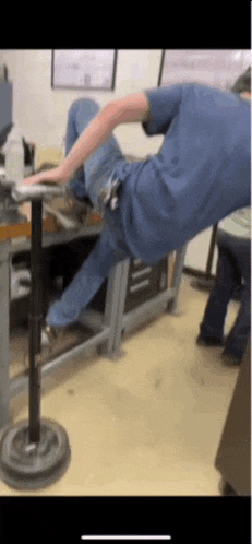 a man in a blue shirt is laying on a table