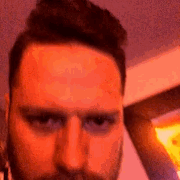 a man with a beard is making a funny face