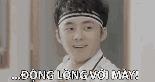 a young man wearing a headband with the words dong long voi may behind him
