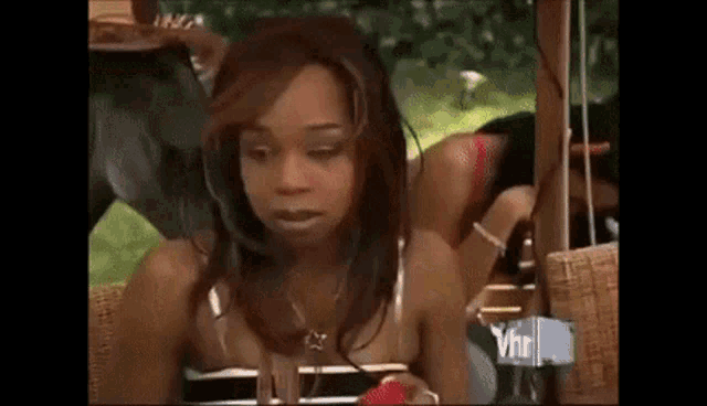 a woman in a bikini is sitting on a couch in a park .