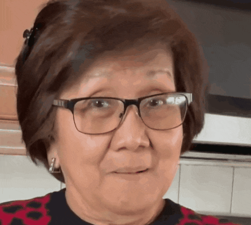 a woman wearing glasses and a red shirt is smiling