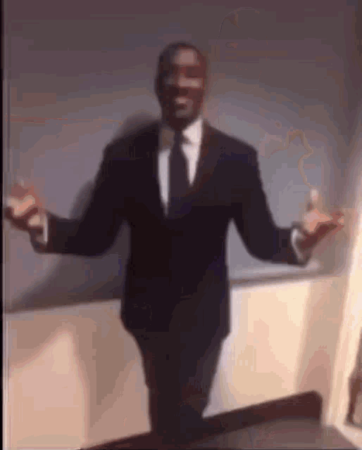 a man in a suit and tie is dancing in a room .