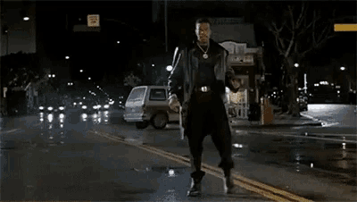 a man is walking down a street with his arms outstretched in front of a sign that says no standing