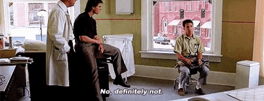 a man in a wheelchair is talking to a doctor and another man in a hospital room .