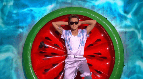 a man is laying on an inflatable watermelon slice in a pool ..