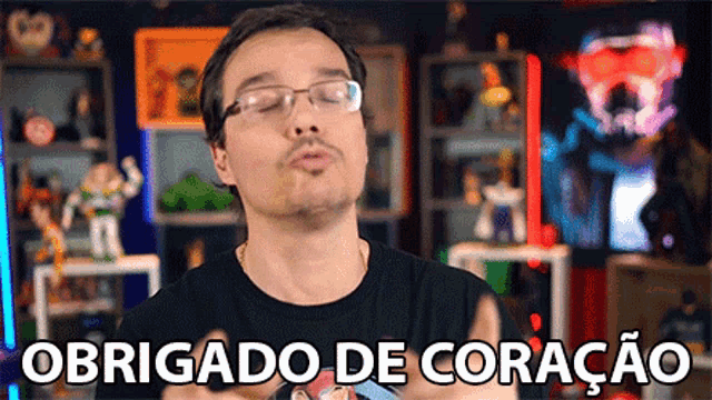 a man wearing glasses is giving a kiss and the words obrigado de coração are behind him