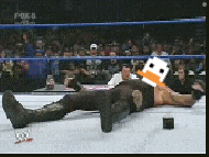 a wrestler is laying on the ground with a duck head on his head