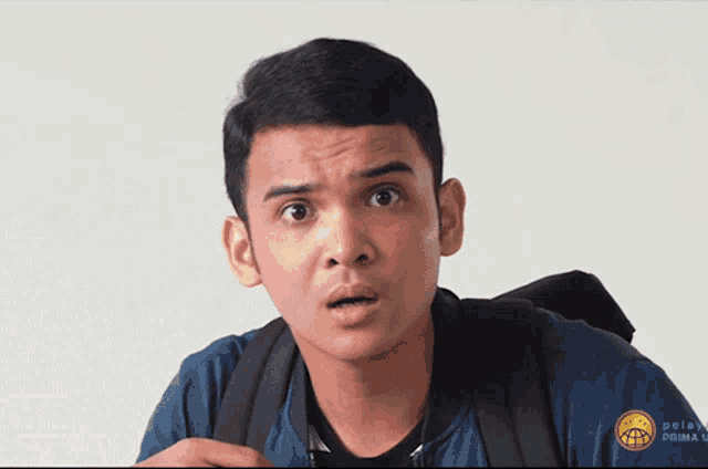 a man wearing a blue shirt that says prima university on it