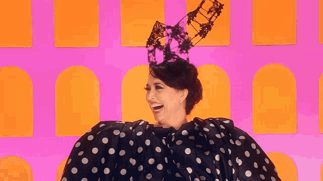 a woman wearing a black and white polka dot dress and a hat