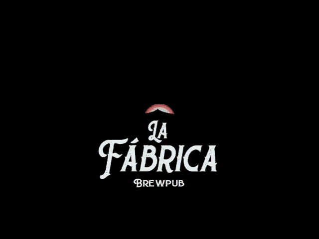 a fireworks display is behind a sign for la fabrica brewpub