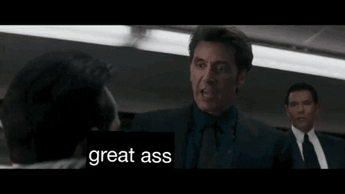 a man is pointing at another man in a movie and the words `` great ass '' are on the screen .