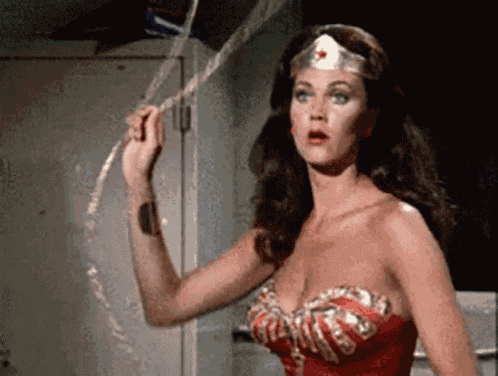 a woman in a wonder woman costume is holding a piece of tape .