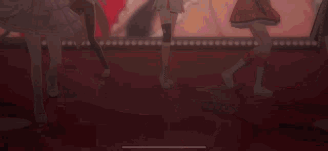 a group of anime girls are dancing on a stage with a red background