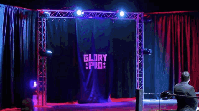 a wrestler is walking through a blue curtain that says story of u