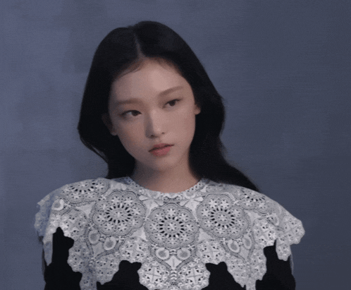 a woman wearing a black and white lace top with a collar