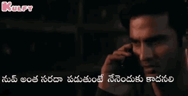 a man is talking on a cell phone with a caption in a foreign language