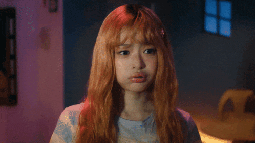 a girl with long red hair is making a funny face