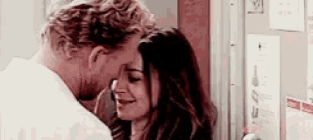 a man and a woman are looking at each other and smiling