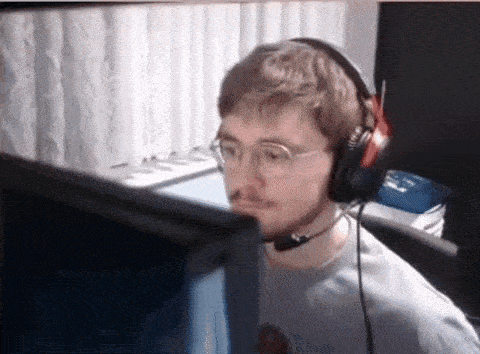 a man wearing headphones and glasses is looking at a computer monitor