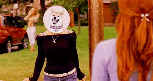a woman with a dog on her head stands in front of another woman