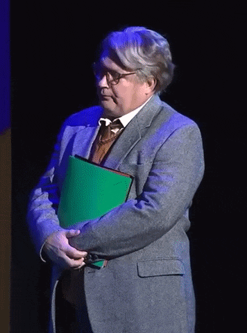 a man in a suit holds a green folder in his hands