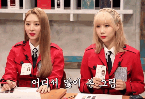 two girls wearing red jackets and ties with korean writing
