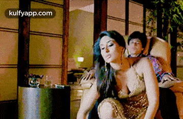 a woman is sitting on a man 's lap in a living room .