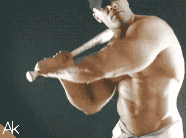 a shirtless man is swinging a baseball bat with the letters ak in the corner