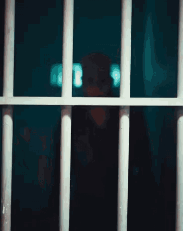 a man in a jail cell with a tattoo on his hand