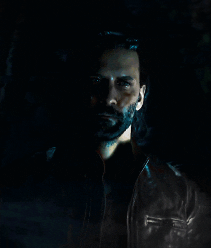 a man with long hair and a beard wearing a leather jacket