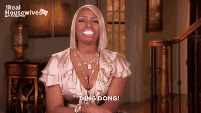 a woman says ding dong in front of a real housewives sign