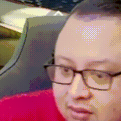a close up of a person wearing glasses and a red shirt